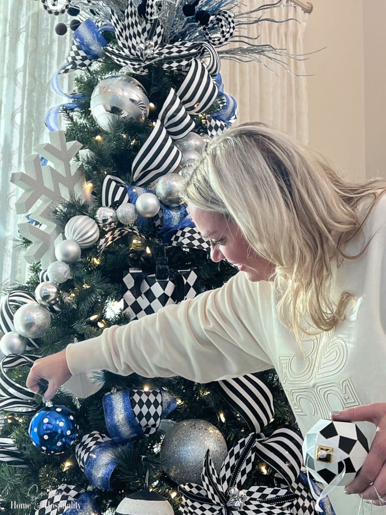 Pro adding final ornaments to the tree