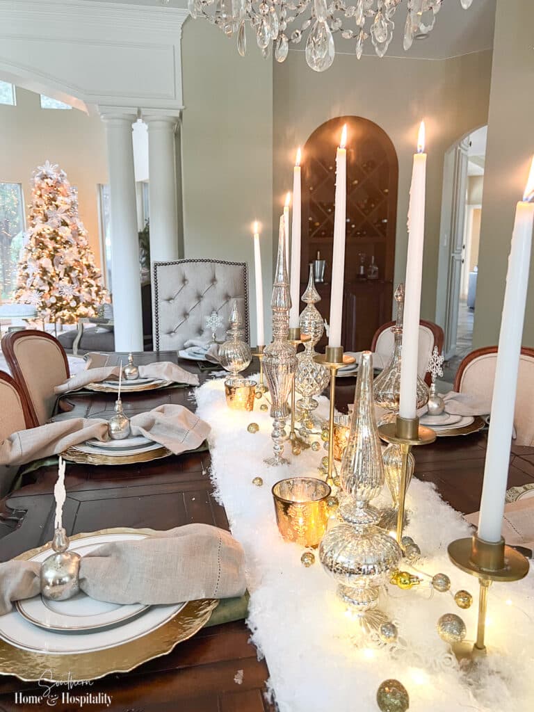 White and gold holiday tablescape with snow and gold candleholders