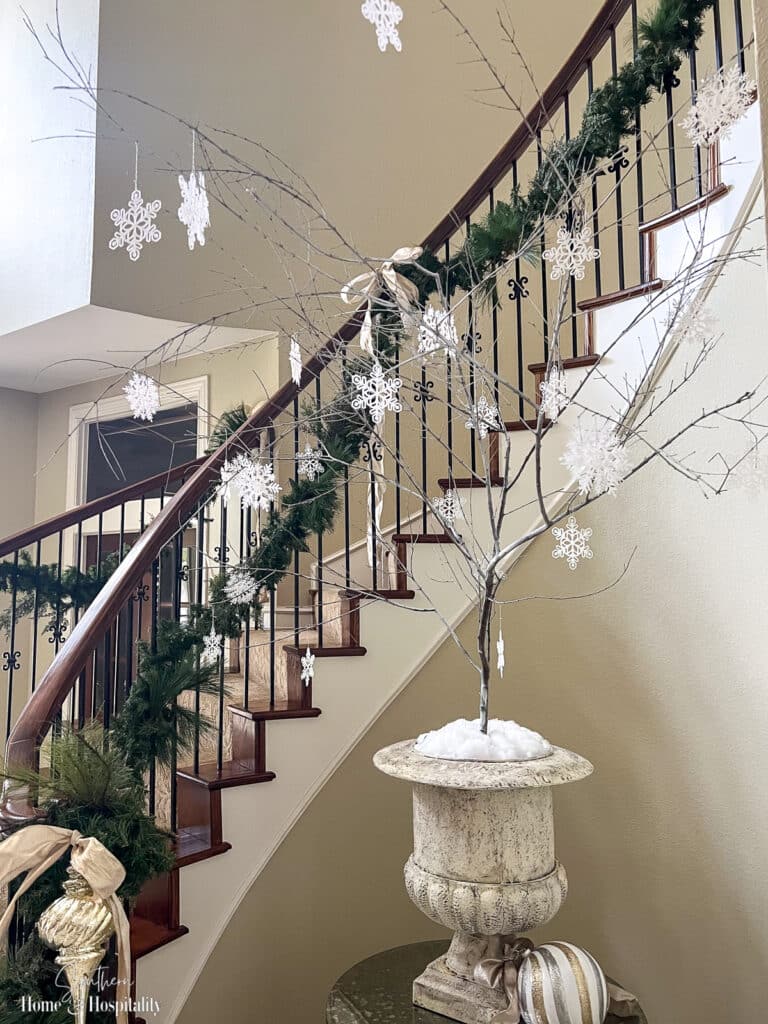 Bare tree branch in pot holiday decor with snowflakes