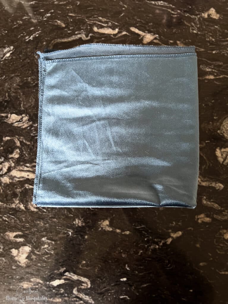 Napkin folded in quarters for bow tie fold