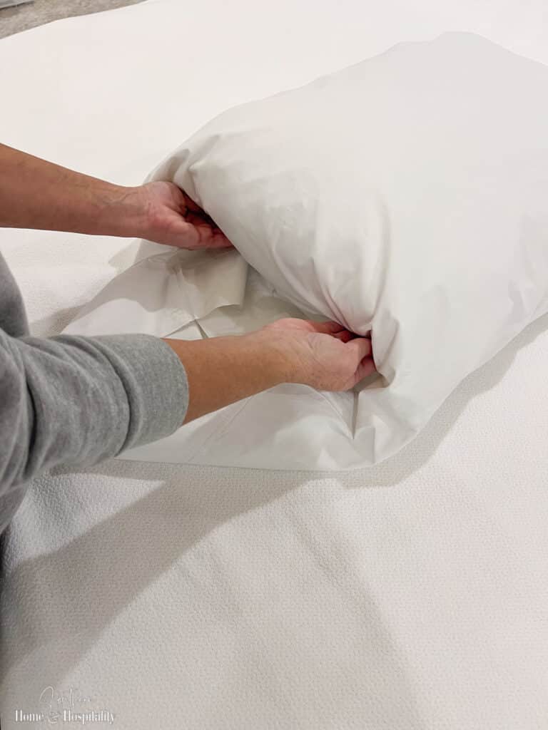 Tucking a pillowcase over the end of a pillow