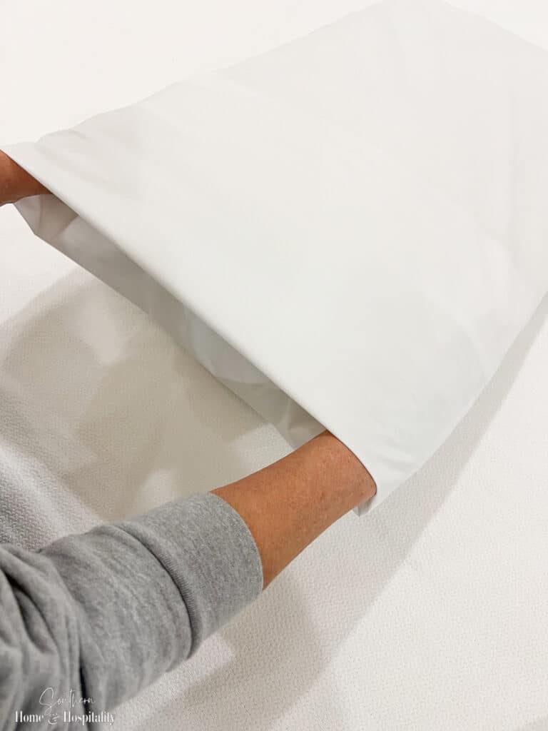 Smoothing a pillowcase with an envelope fold
