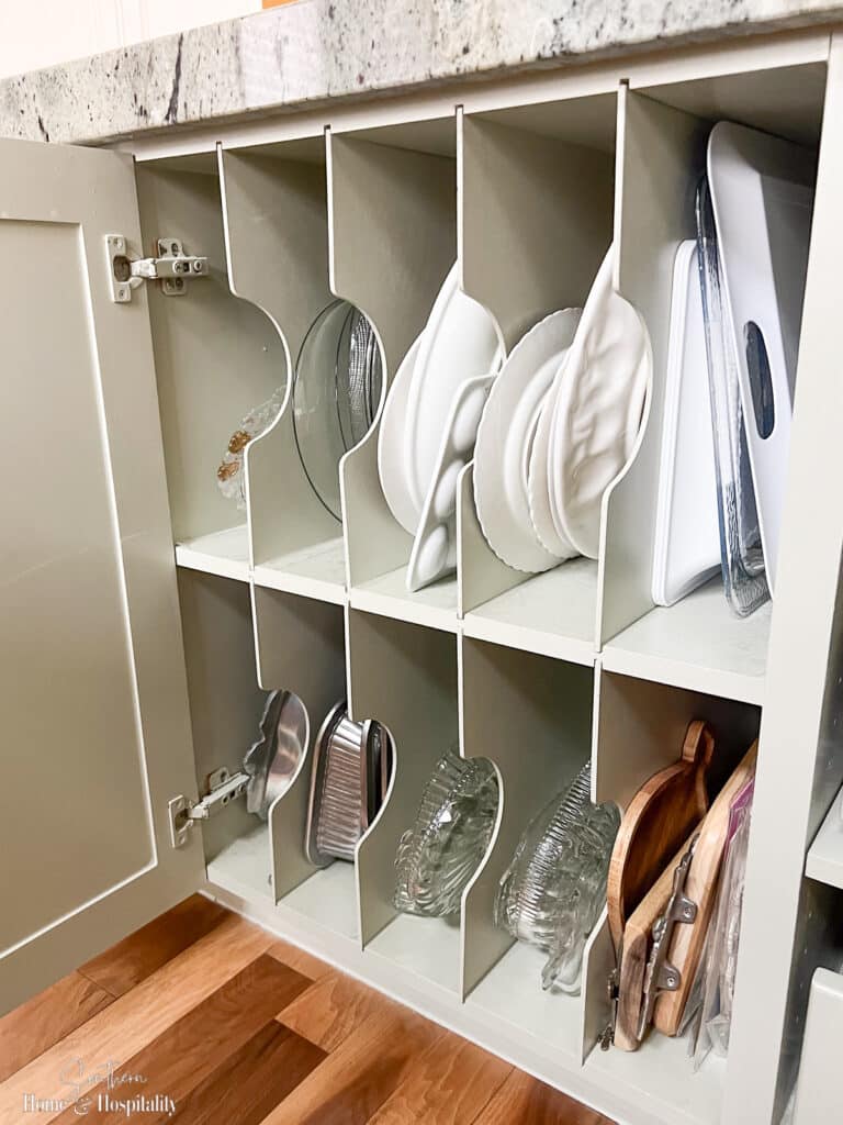 Two level vertical dividers in kitchen cabinet for serving platters and dishes