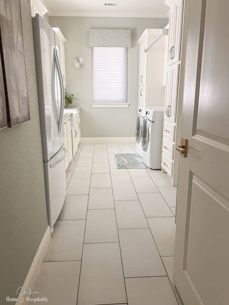 Organized white and soft green laundry room