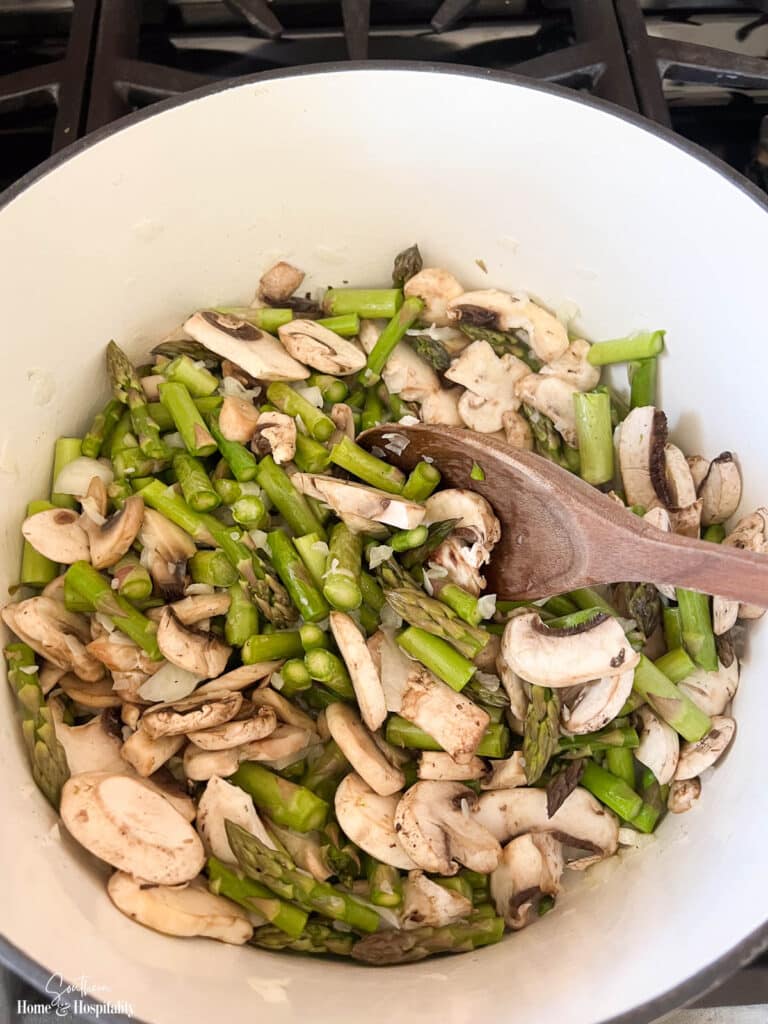 Sauteeing asparagus spears and mushrooms in butter