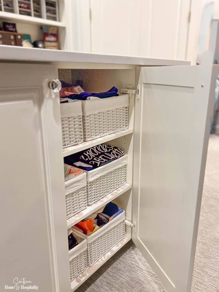 Wicker storage bins in closet island cabinet