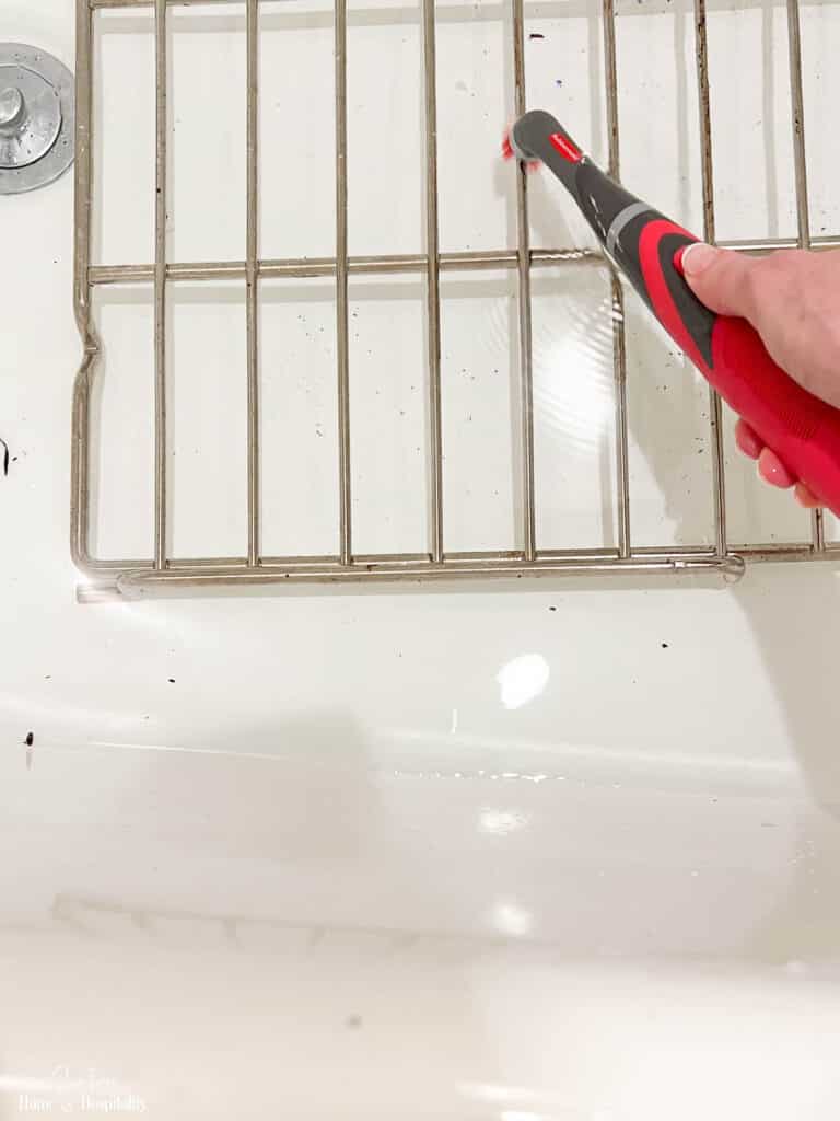 Scrubbing grime off of oven racks with power scrubber