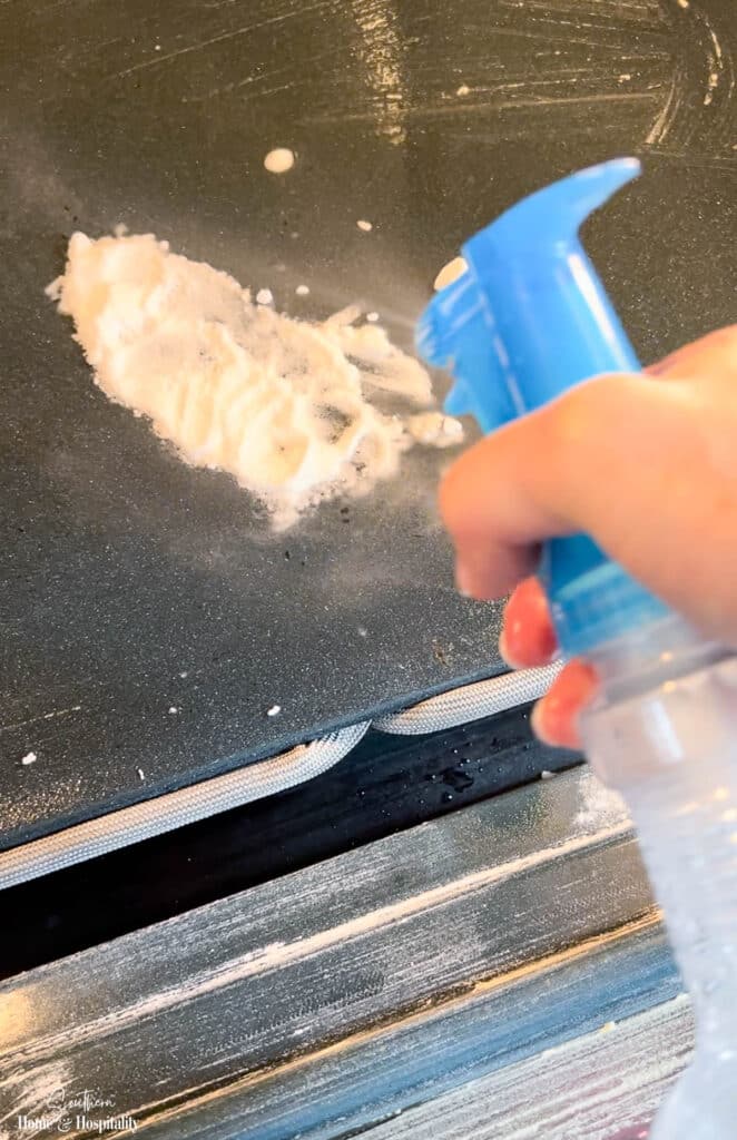 Spot cleaning oven stain with baking soda and vinegar