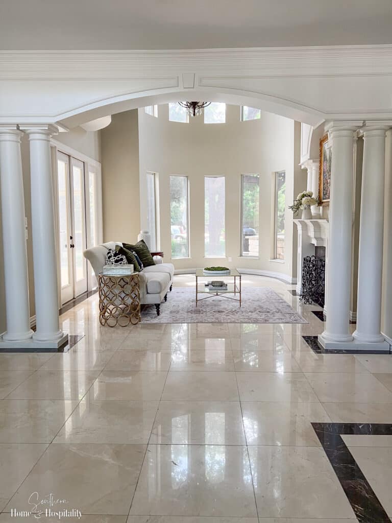Living room with columns, millwork arches, and marble floors