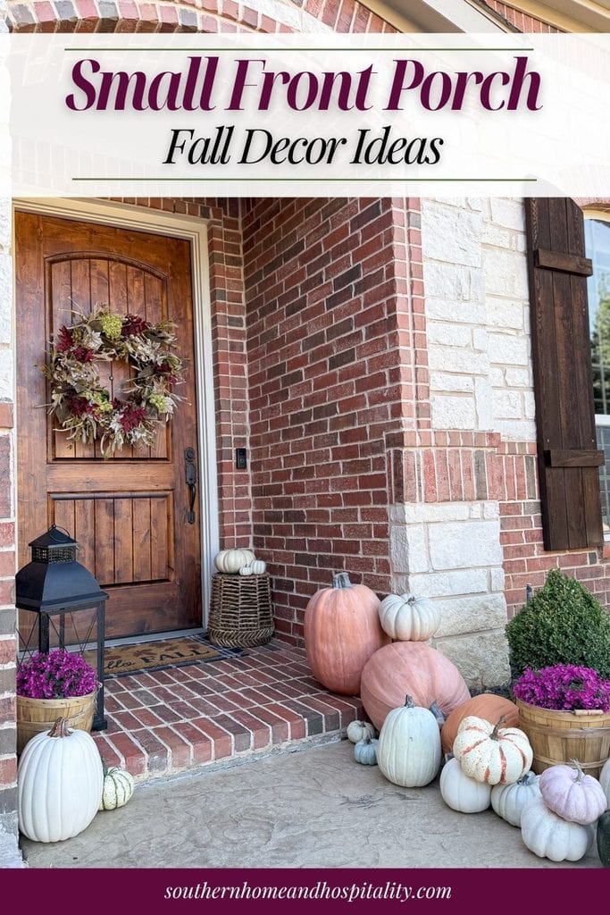 Small front porch decorated with pumpkins, purple mums, a fall wreath, and layered doormats for autumn.