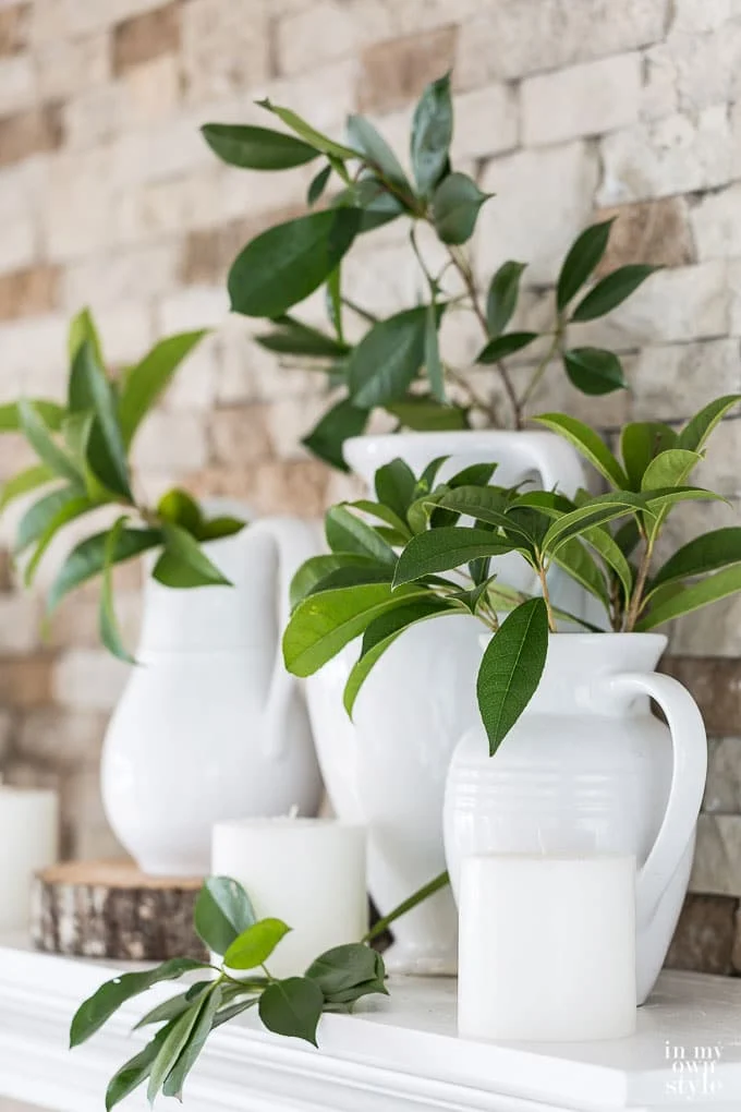 Collection of white vases with greenery