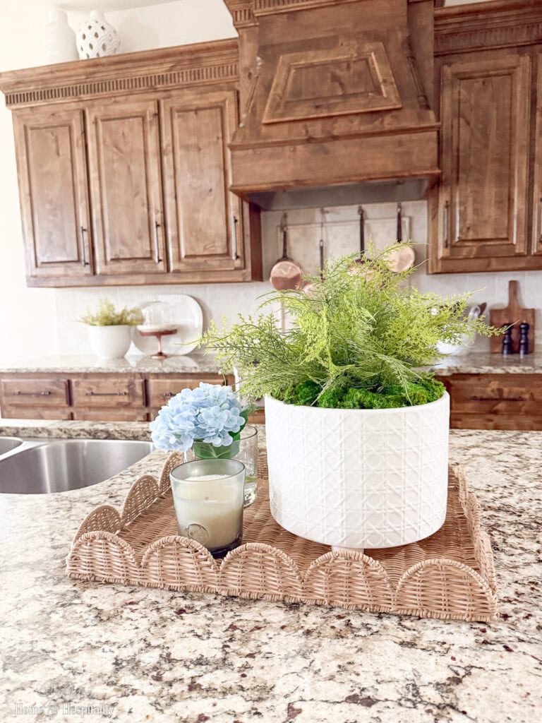 Collage of styled kitchen counter vignette example with a tray, plant, and candle.