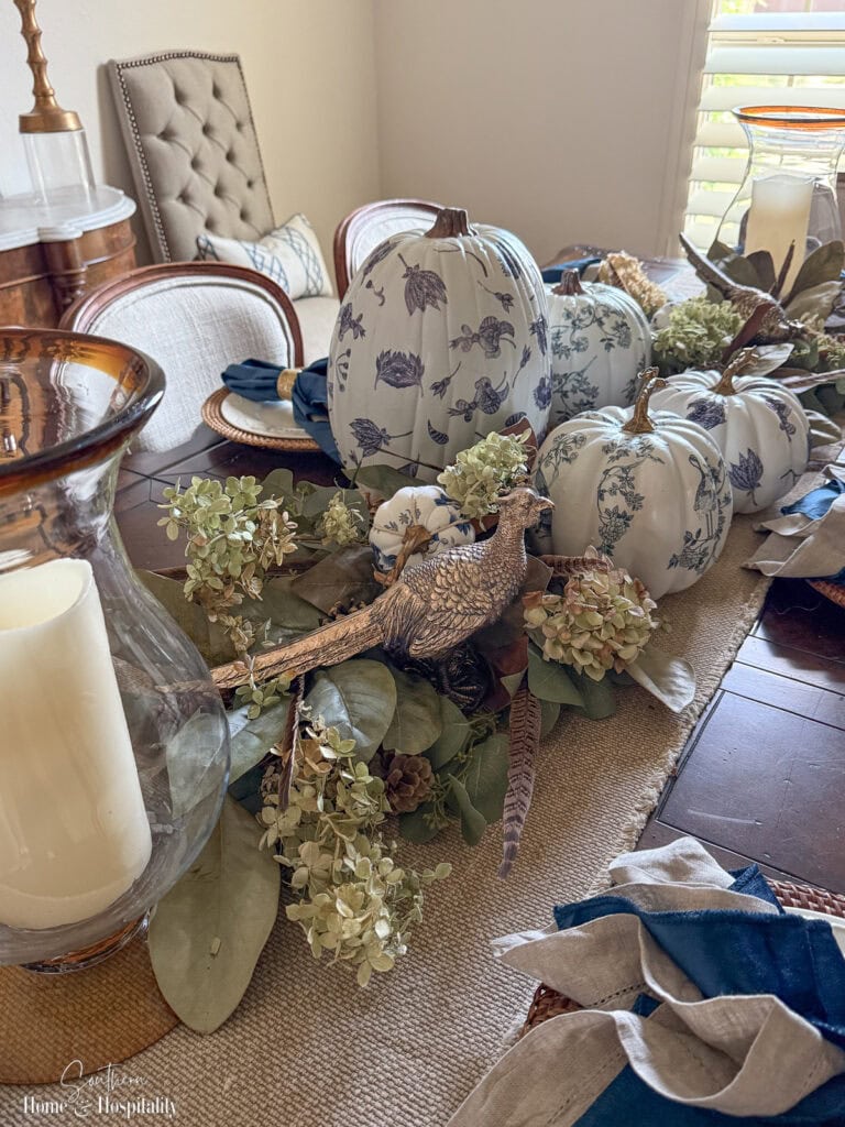 Chinoiserie pumpkins and pheasant accents in fall centerpiece.