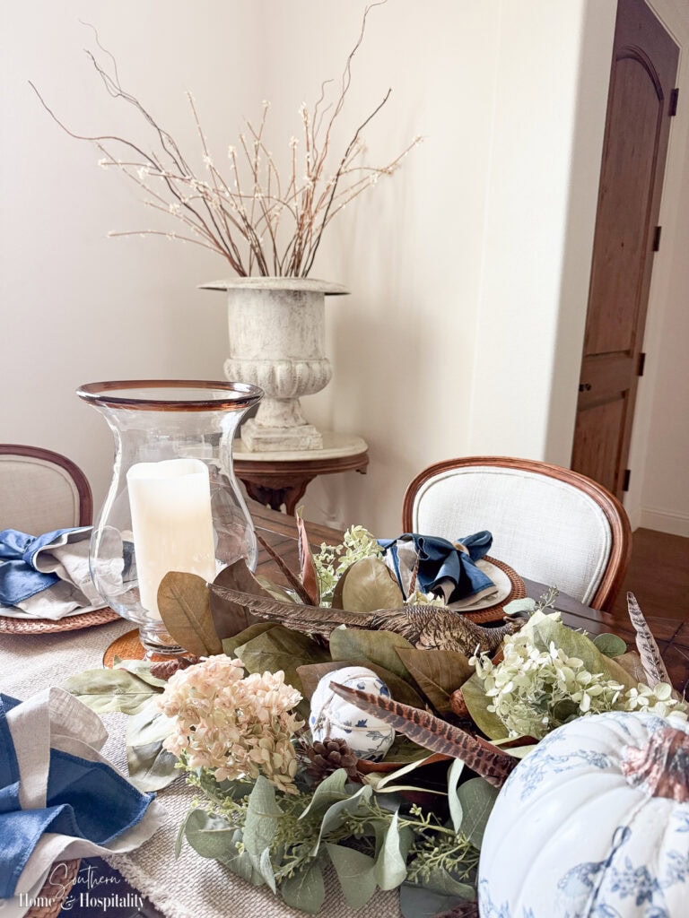 Fall floral branches in urn with willow sticks in dining room corner.