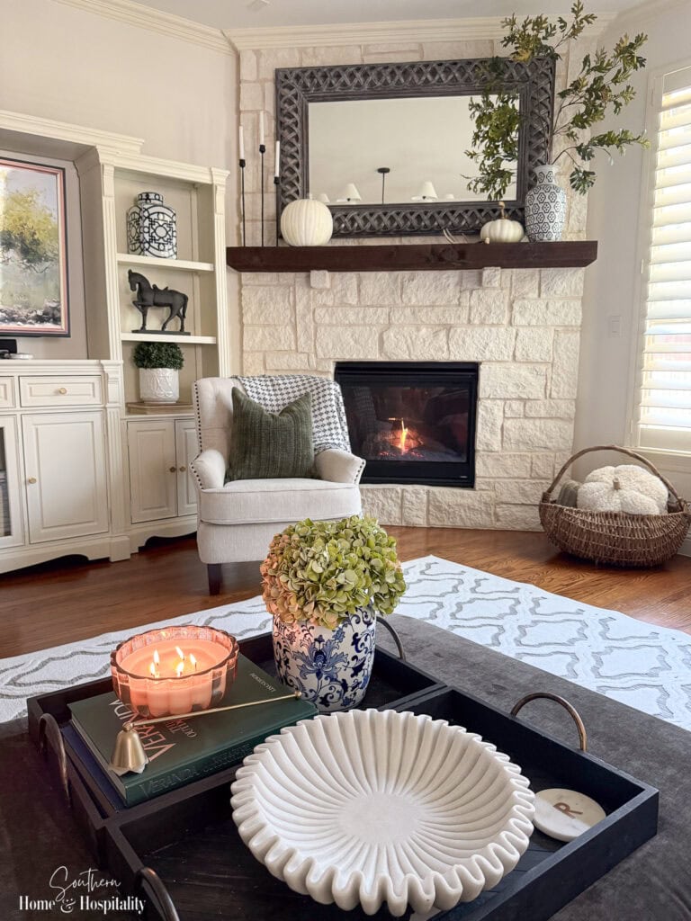 Coffee table tray with hunter green books and fall candle.