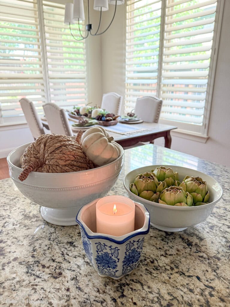 Kitchen island decorated with wicker pumpkins, baby boos, and a fall candle.