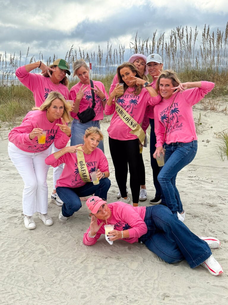 60th birthday girls trip on the beach in matching shirts