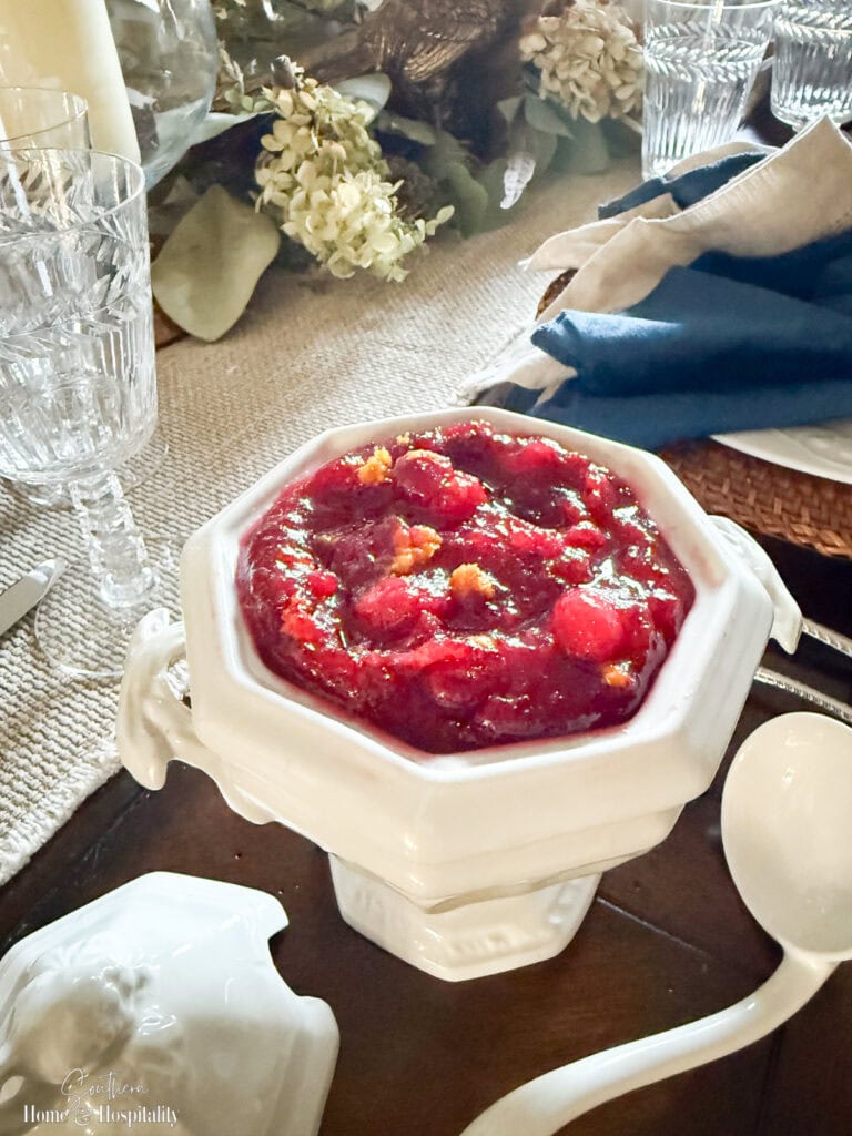 Glossy homemade cranberry sauce in a vintage white tureen, ready to serve for Thanksgiving or Christmas dinner.