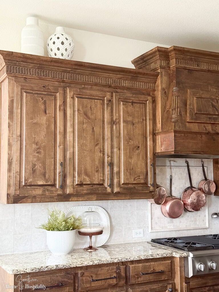 Modern white vases on top of upper cabinets to show uncluttered decor style