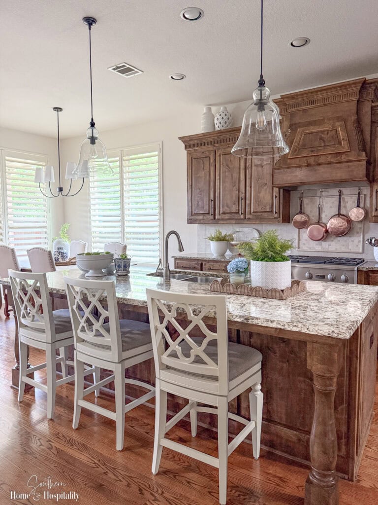 Traditional kitchen with wood cabinets and space above decorated simply with large pottery, showing how to decorate above kitchen cabinets without clutter