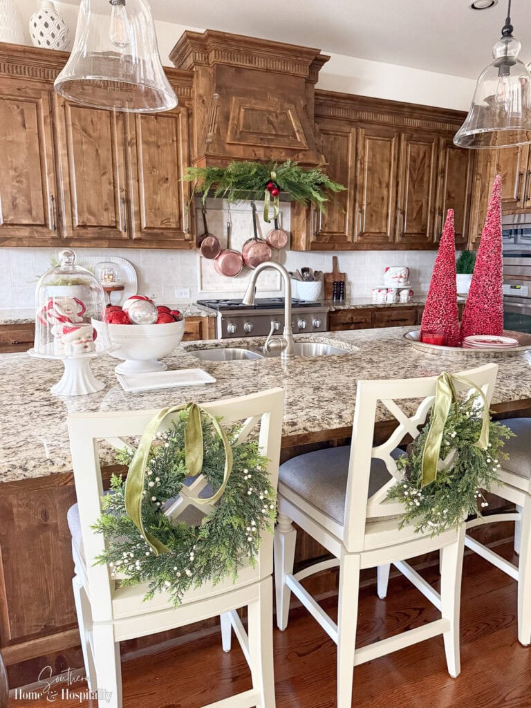 Coordinated red, green, and white Christmas kitchen decor connecting to family room for open concept design.