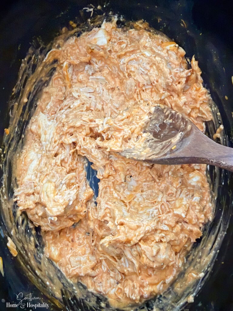 Buffalo chicken dip almost melted and creamy in the slow cooker