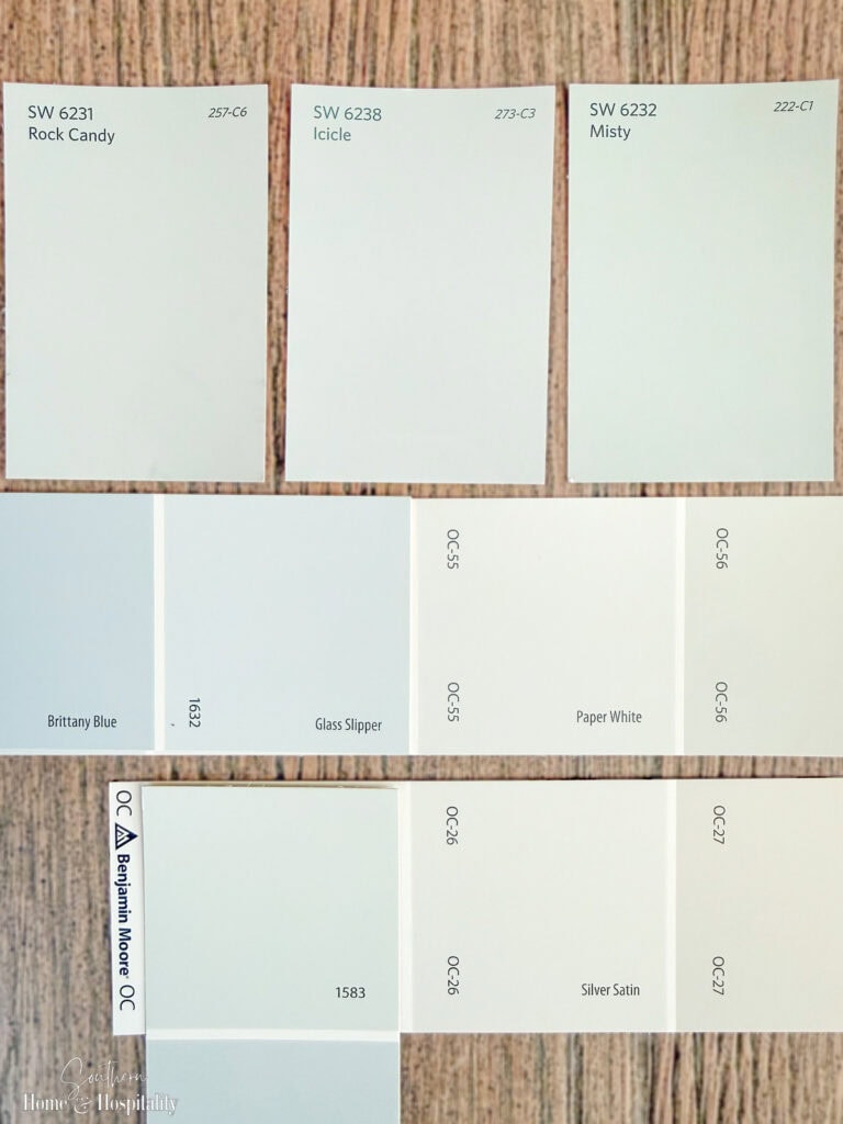 Light blue-gray paint samples from Sherwin-Williams and Benjamin Moore shown side by side for small room paint color comparison.