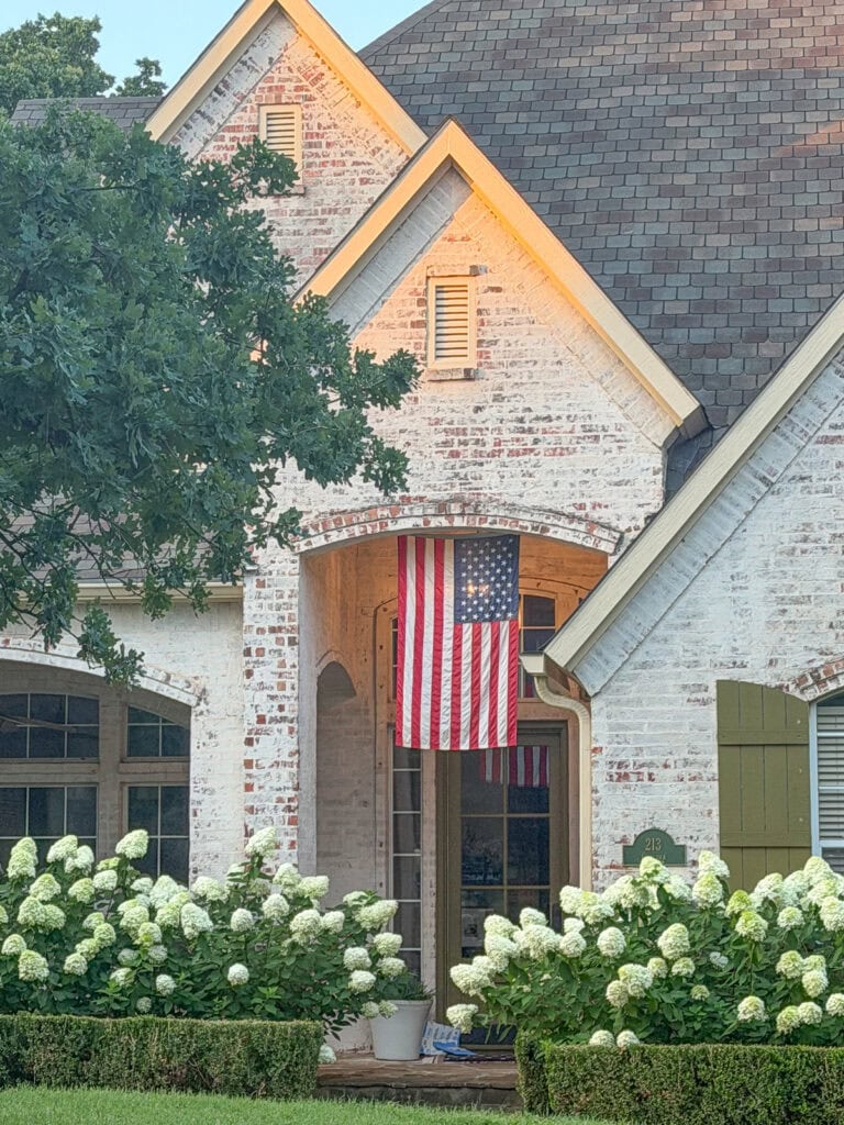 American flag on porch with limelight hydrangeas