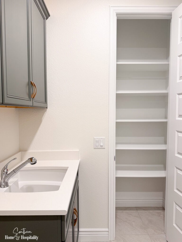 Laundry room with built-in storage, utility sink, and walk-in pantry shelving