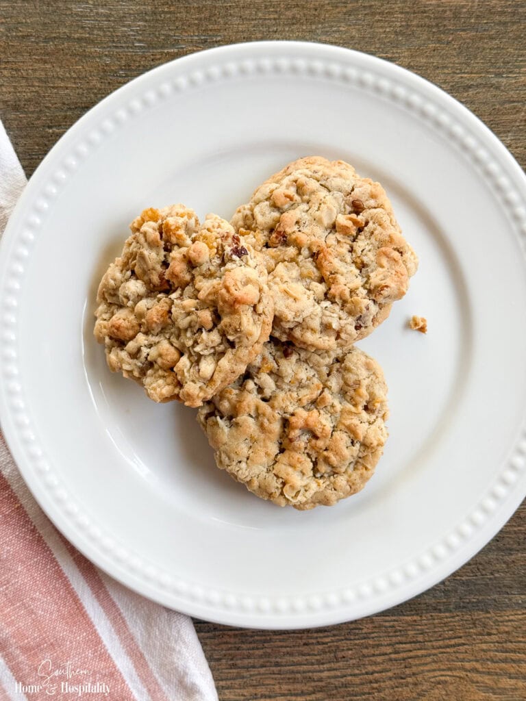 Old-Fashioned Ranger Cookies on a white plate with a soft, chewy texture and crunchy oats, cornflakes, coconut, and pecans.