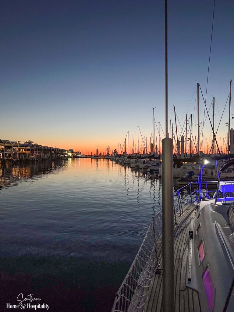 Boats docked at a marina as the sun sets on a peaceful summer evening.