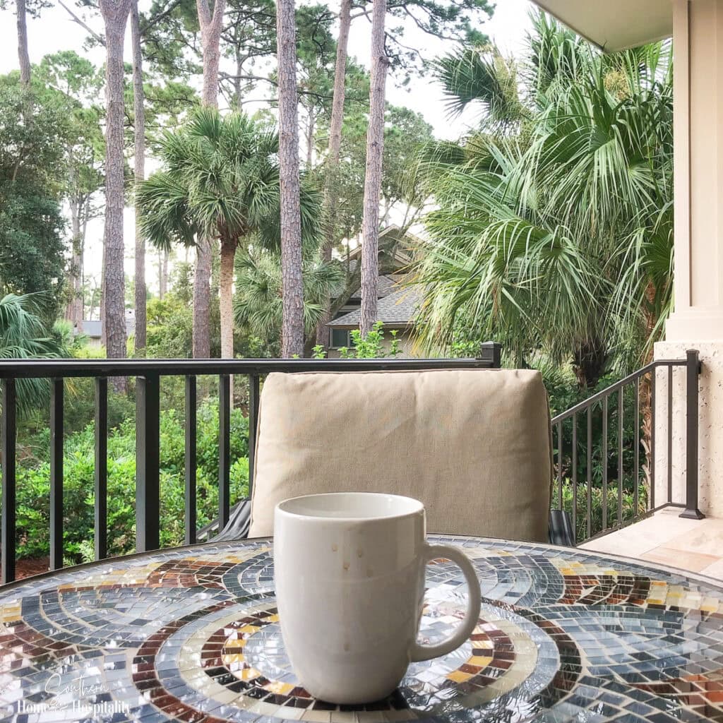 Morning coffee on a porch overlooking a peaceful summer landscape.