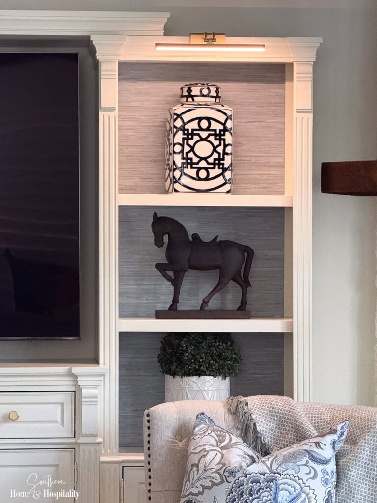 Updated entertainment center with a rechargeable picture light on highlighting the shelves.