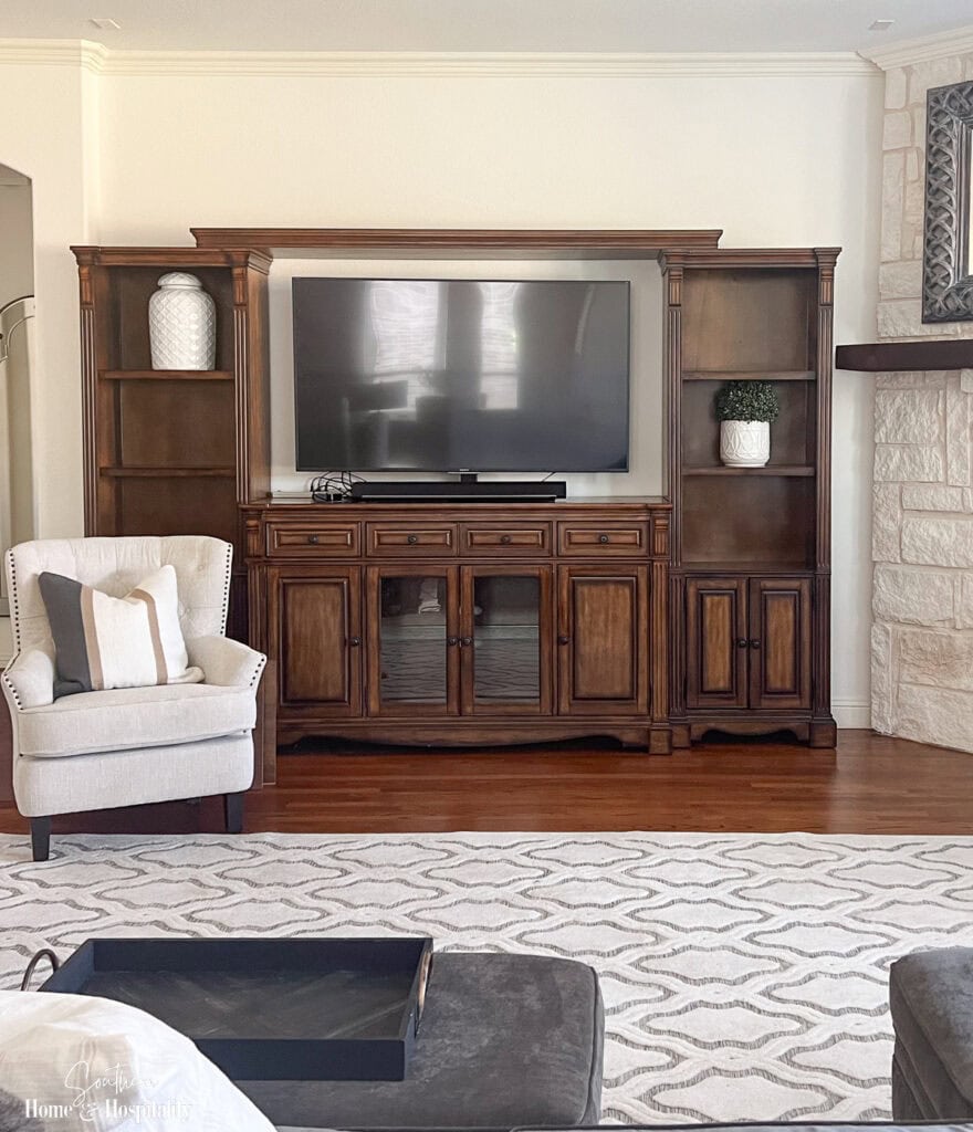 The original dark wood finish and cabinet details on the entertainment center before the makeover.