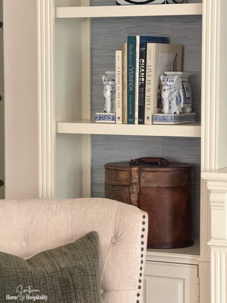 Leather box, blue and white porcelain, and vintage-style accessories on fall living room shelves