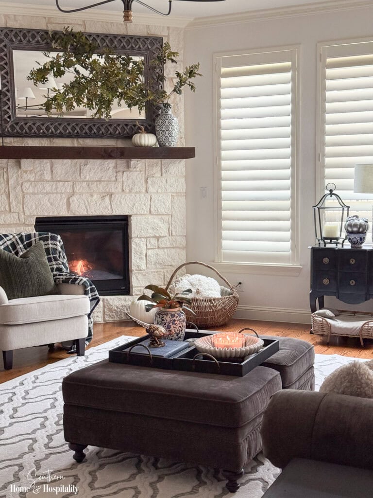 Fall living room with dramatic oak branches, blue and white decor, plaid, and warm traditional textures