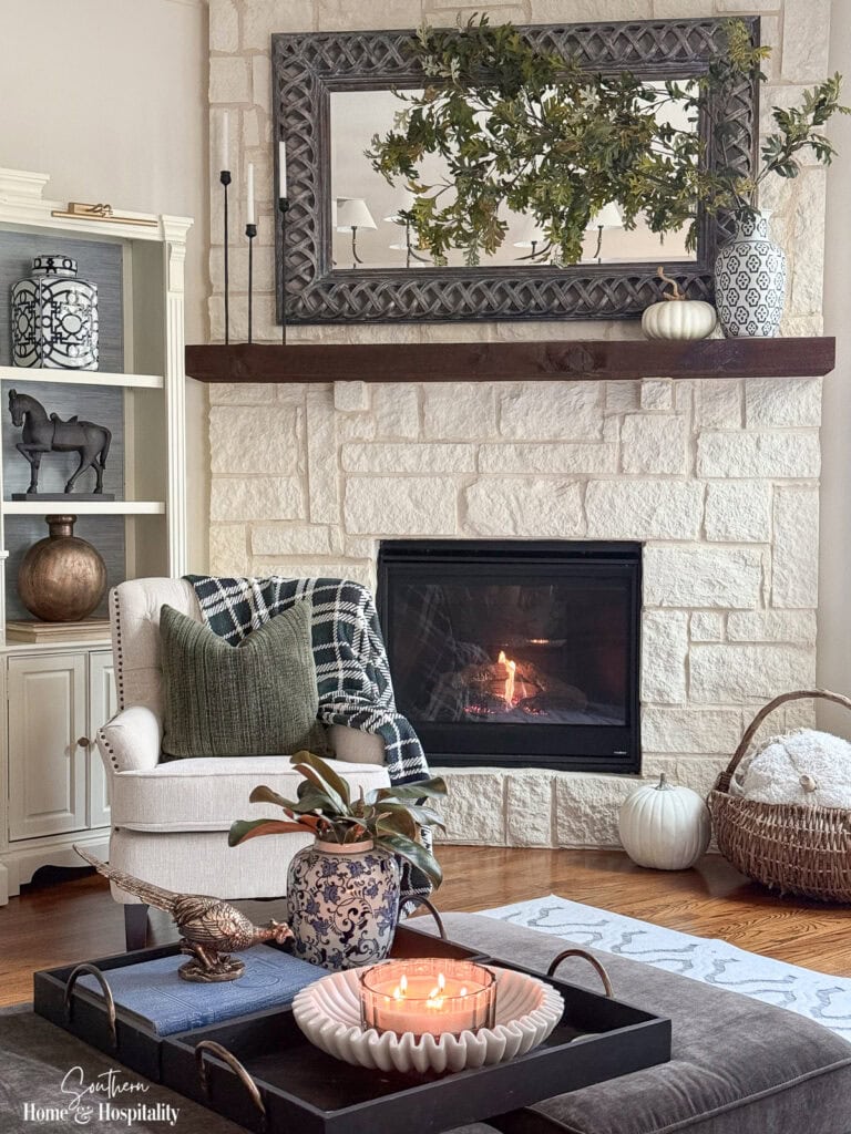 Traditional living room decorated for fall with blue and white, plaid, leather, and rich green and brown accents