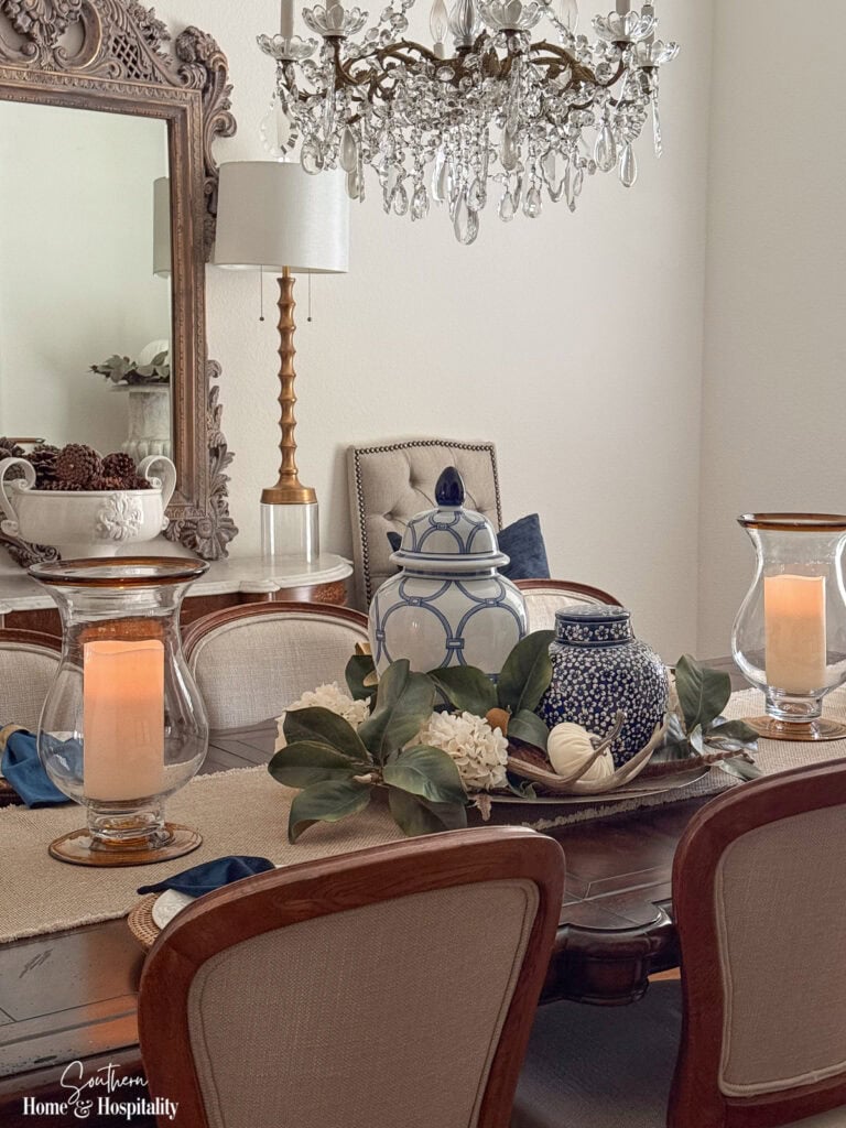 Ralph Lauren-inspired fall dining table with magnolia leaves and cream hydrangeas extending from a central tray centerpiece