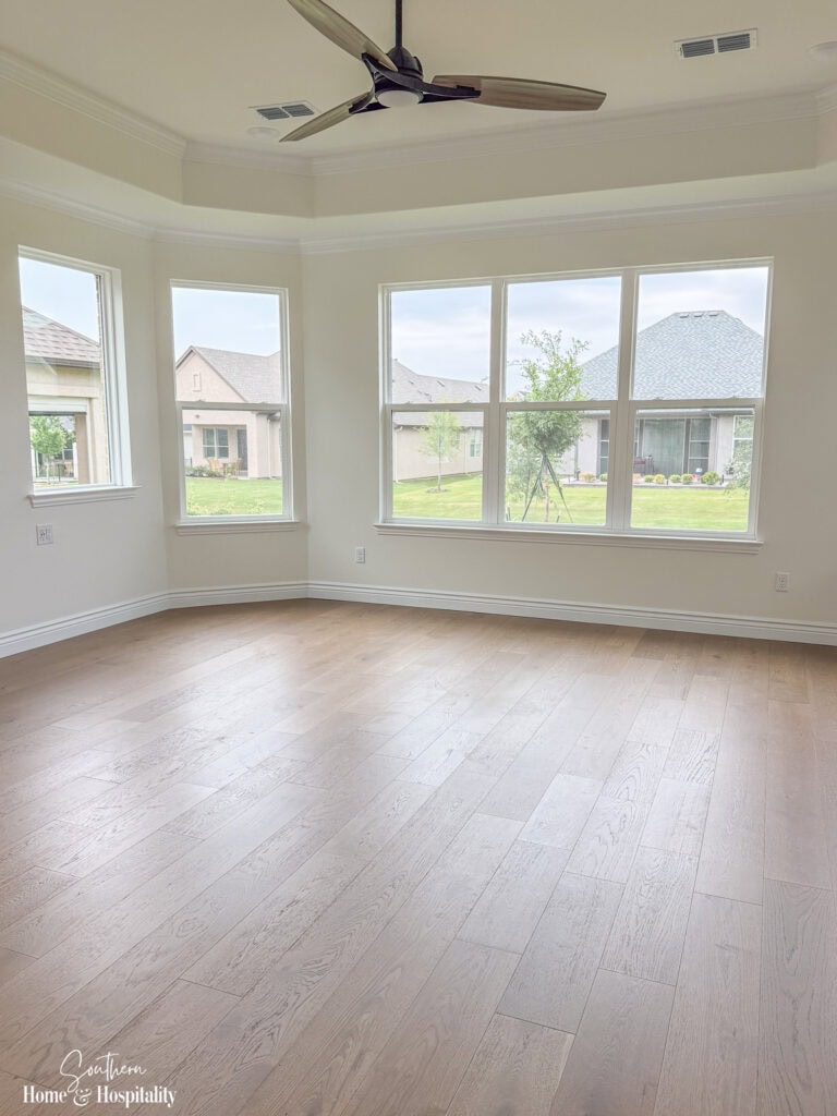 New home bedroom with a large bank of windows and wood flooring
