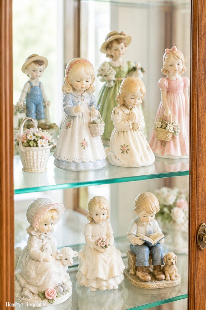 Collection of vintage porcelain figurines displayed together on a shelf.