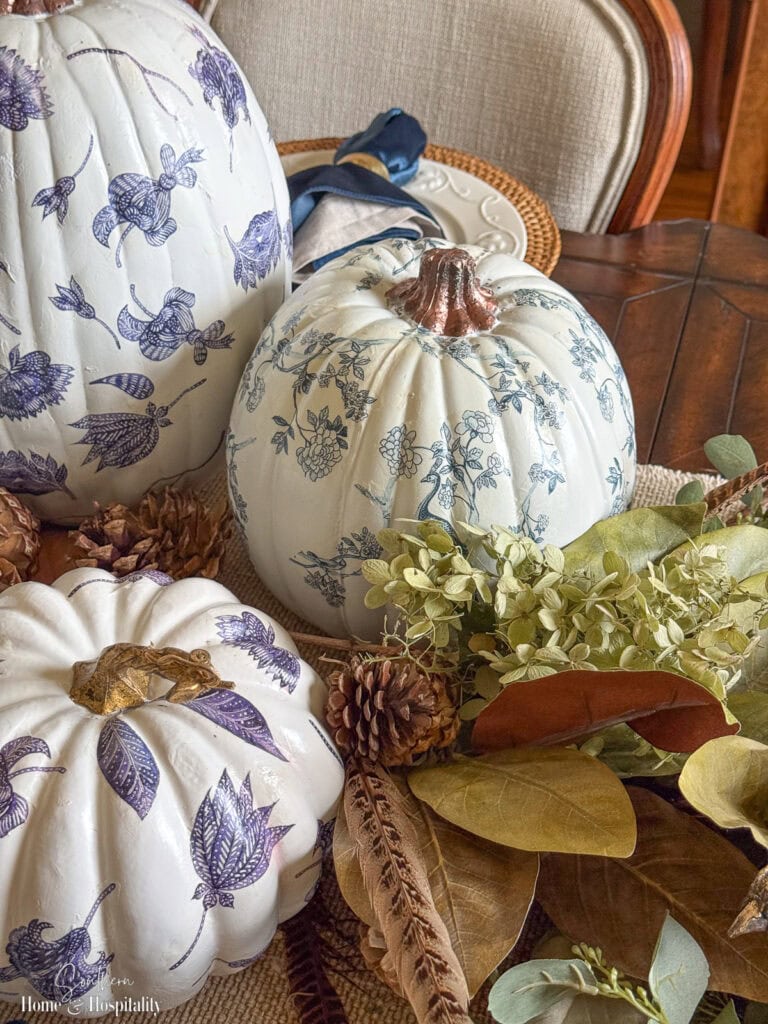 Blue and white chinoiserie pumpkins in a fall table centerpiece with magnolia leaves and hydrangeas