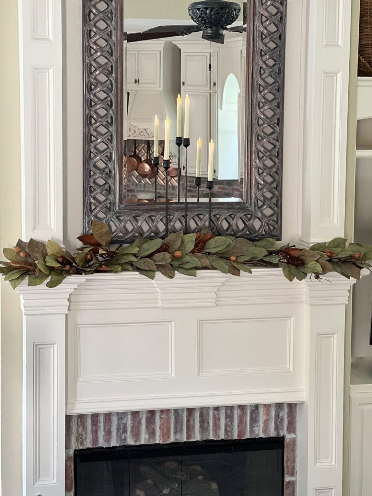 Faux dried magnolia candle rings opened and layered across a fall mantel