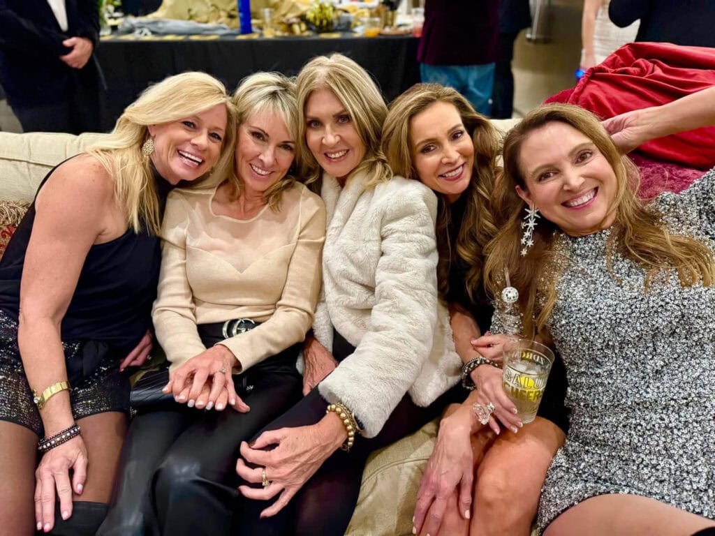 Five girlfriends dressed up and sitting together at a New Years Eve celebration