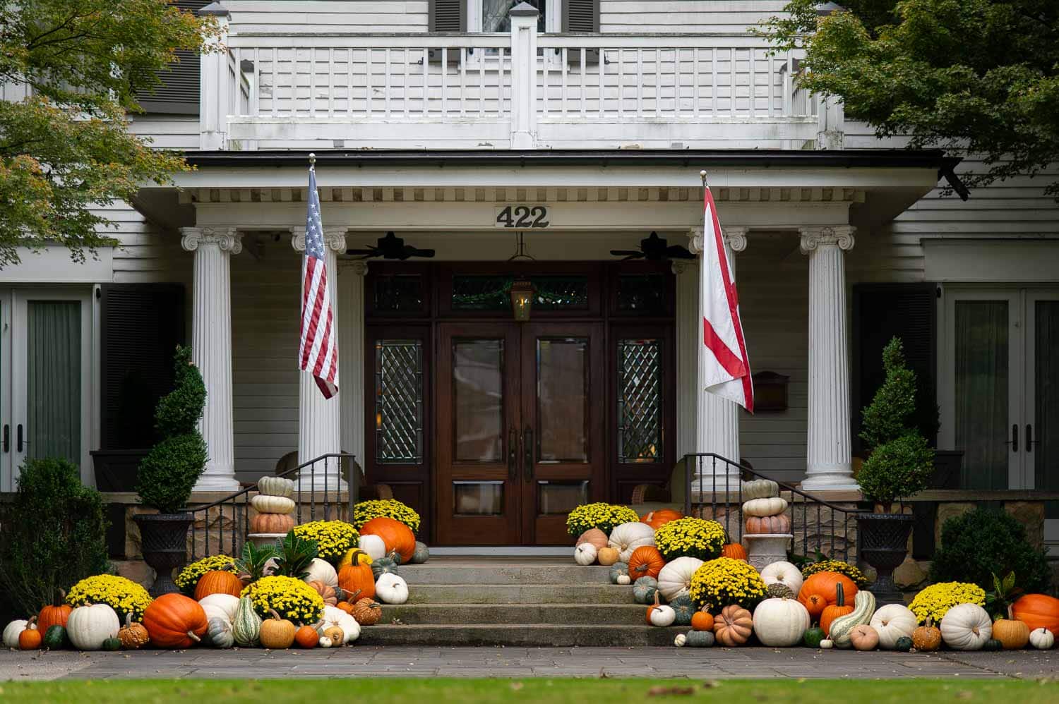 Classic southern home porch piled with pumpkins and mums for fall