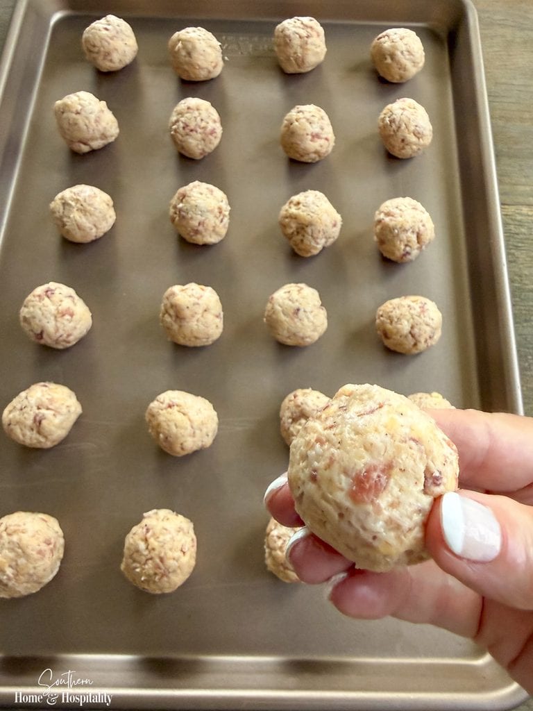 Unbaked homemade sausage balls formed and arranged on a baking sheet before chilling