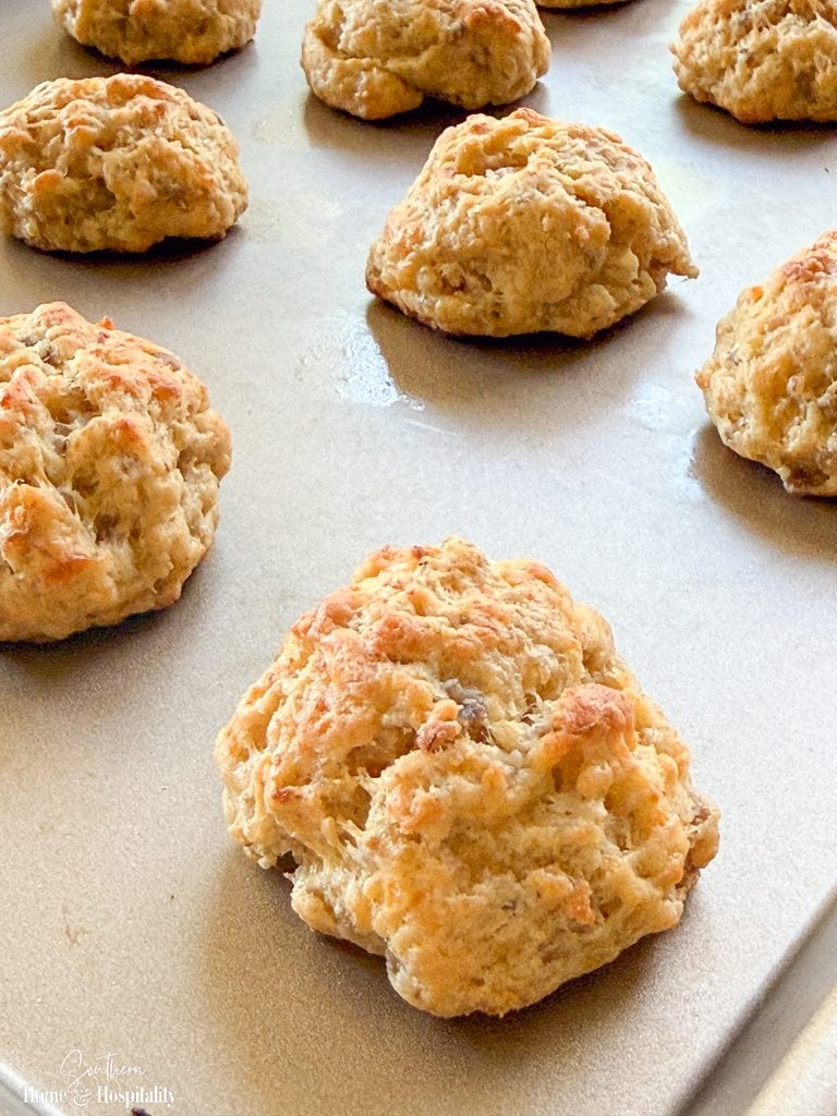Baking sheet of baked Southern sausage balls made with sharp cheddar and cream cheese